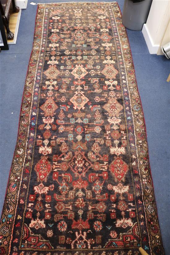 A Hamadan black ground rug, 9ft by 3ft 2in.